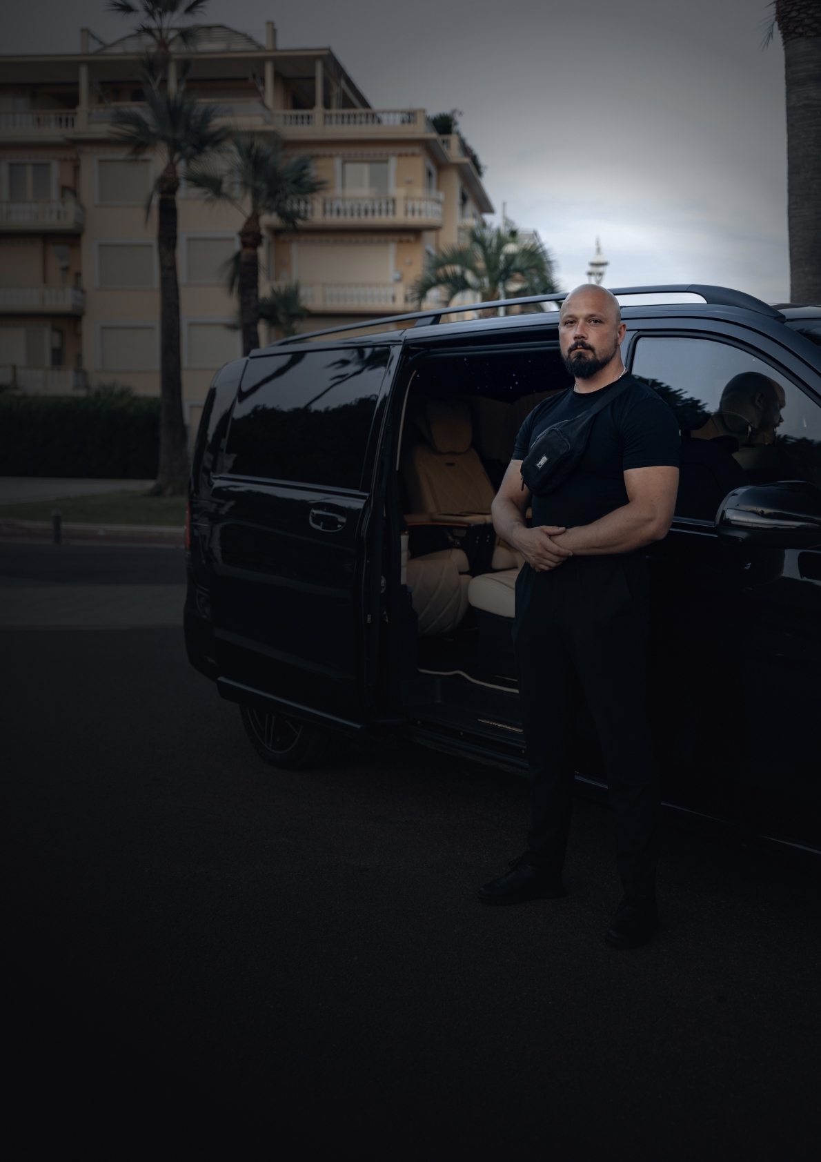 LEON security driver standing beside a black van